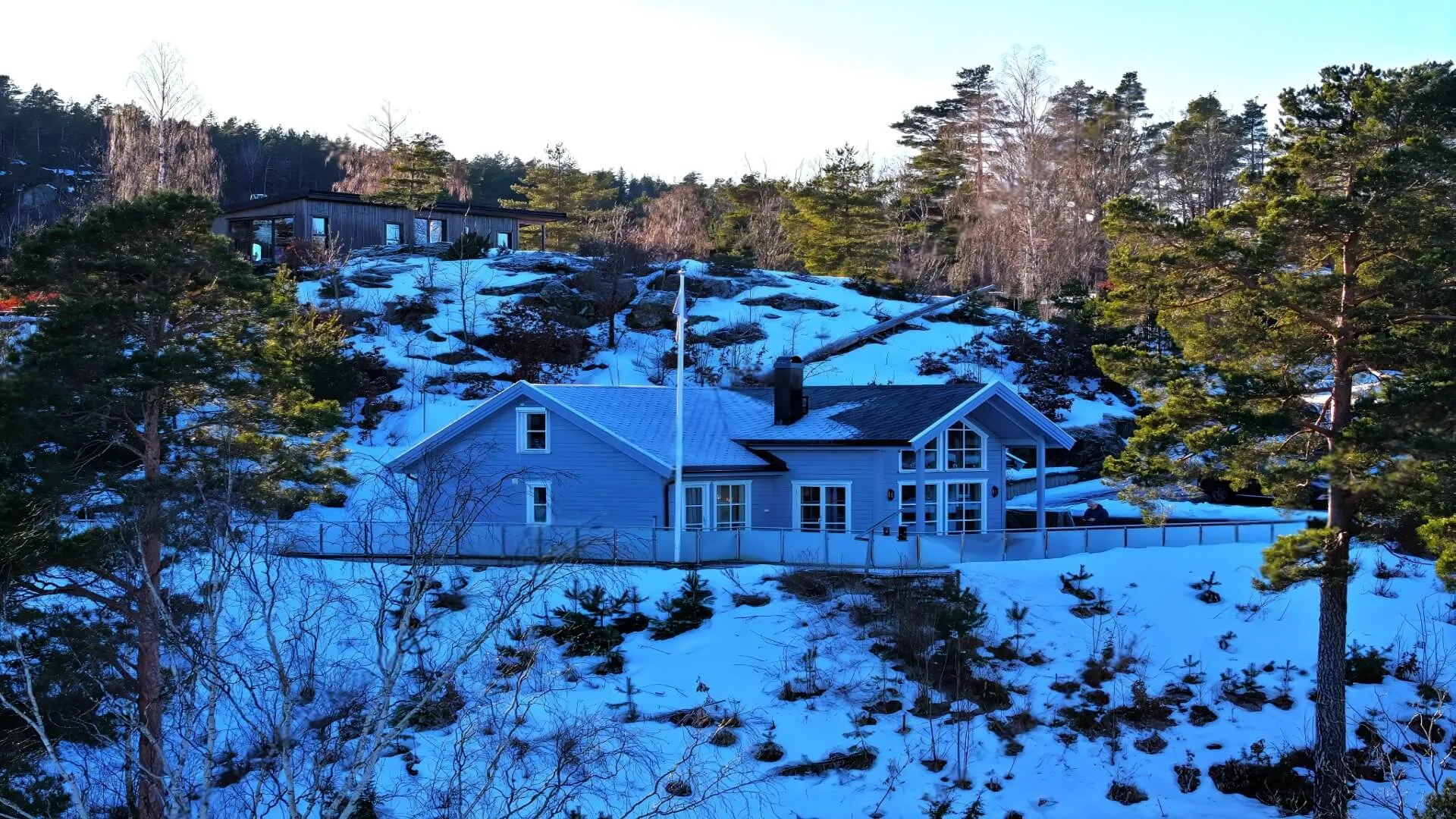 Dronefoto av hytter i snødekt skogsterreng